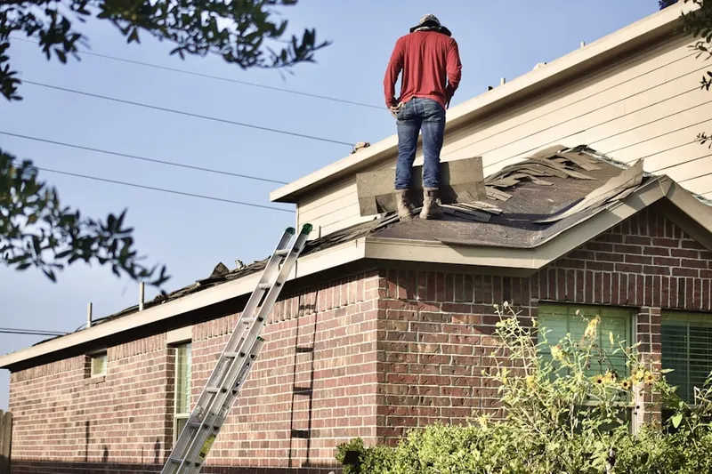 Professional roofer working on a residential roof in Helfrichsville